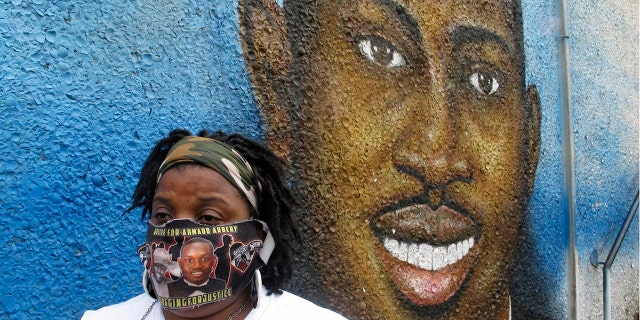 Thea Brooks stands in front of a mural of her slain nephew, Ahmaud Arbery, in Brunswick Ga. on Oct. 5, 2021.