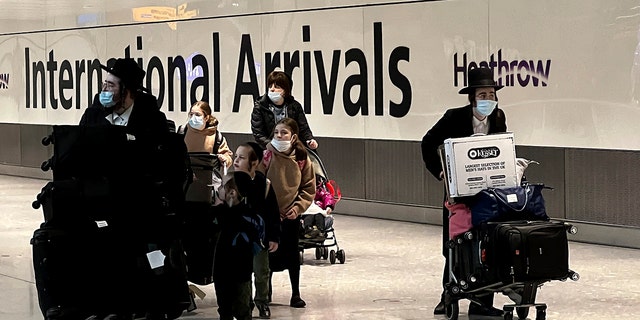 Passengers arrive at Heathrow Airport in London on Monday, Nov. 29, 2021.