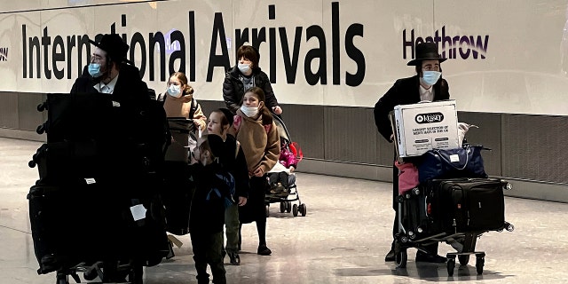 Passengers arrive at Heathrow Airport in London on Monday, Nov. 29, 2021.