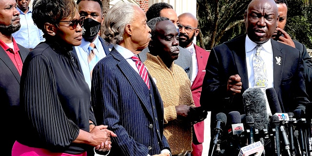 Family attorney Benjamin Crump, right, speaks as Marcus Arbery, second from right, his former wife Wanda Cooper, left, and the Rev. Al Sharpton listen outside the Glynn County courthouse, Wednesday, Nov. 10, 2021, in Brunswick, Ga. Rev. Sharpton led a prayer and spoke out against injustice during the noon break in the trial of three men charged with murder in Ahmaud Abery's shooting death.