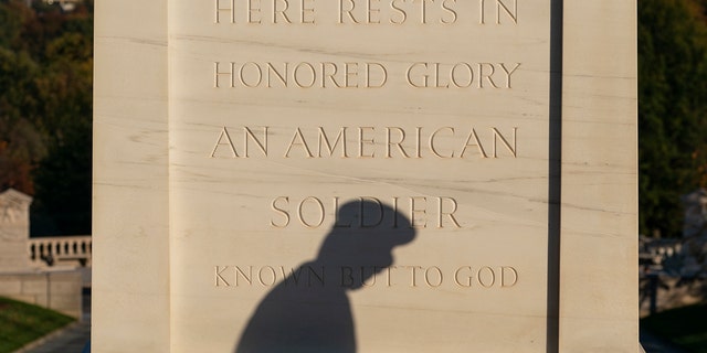 The shadows of a soldier with the 3rd U.S. Infantry Regiment, known as "The Old Guard," is seen as he moves flowers during a centennial commemoration event at the Tomb of the Unknown Soldier, in Arlington National Cemetery on Wednesday in Arlington, Virginia. 