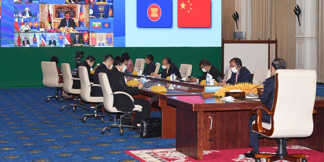 In this photo provided by the An Khoun Sam Aun/National Television of Cambodia, Cambodia's prime minister, right, joins an online meeting of the ASEAN-China special summit at Peace Palace in Phnom Penh, Cambodia, Monday, Nov. 22, 2021.