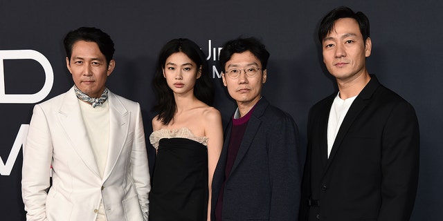 From left, Lee Jung-jae, Jung Hoyeon, Hwang Dong-hyuk and Park Hae Soo arrive at a red carpet event for 'Squid Game' in November 2021.