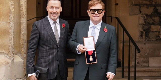 Sir Elton John with his partner David Furnish, after being appointed a Member of the Order of the Companions of Honor for services to music and charity at an investiture ceremony at Windsor Castle, in Windsor, England, on 10 November 2021.