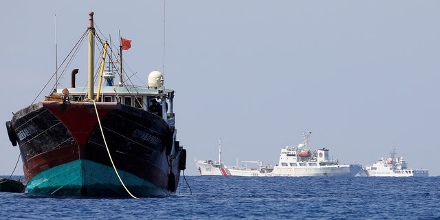 China Coast Guard vessels patrol past a Chinese fishing vessel at the disputed Scarborough Shoal, April 5, 2017.