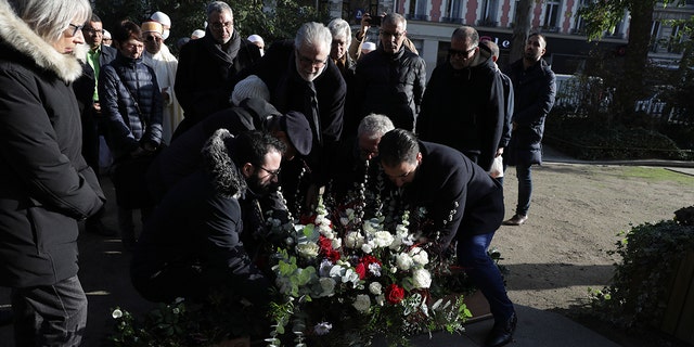 Members of the Muslim community lay a wreath of flowers before paying their homage to the victims of the 2015 attacks, outside the Bataclan concert hall in Paris on Friday, the eve of the sixth anniversary of the attacks.