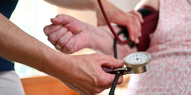 A nurse measures the blood pressure of a resident of a retirement home in her room. Recently, one hospital reported that nearly one-fifth of adults with hypertension are on medication that increases blood pressure.
