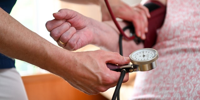 A nurse measures the blood pressure of a resident of a retirement home in her room. 