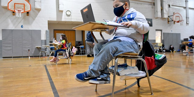 Jandel Diaz does his school work on a laptop computer. Recently, a state court tossed a mask mandate for Pennsylvania schools.