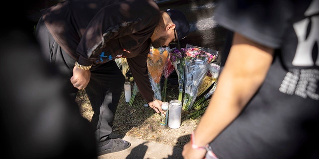 A man places a candle at a memorial in Houston for the victims of the Astroworld music festival on Sunday.
