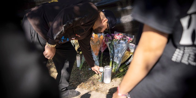 A man places a candle at a memorial in Houston for the victims of the Astroworld music festival on Sunday.