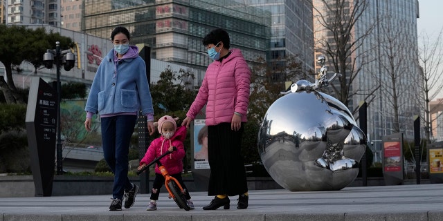 Residents wearing masks past by artwork outside a mall in Beijing, China, on Saturday.