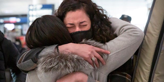 La journaliste du Wall Street Journal, Julie Wernau, embrasse une collègue avant son départ à l'aéroport international de Pékin, le 28 mars 2020.