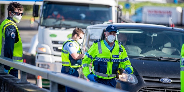 Police inspect vehicles at a road block on the outskirts of Auckland, New Zealand on Sept. 30, 2021.