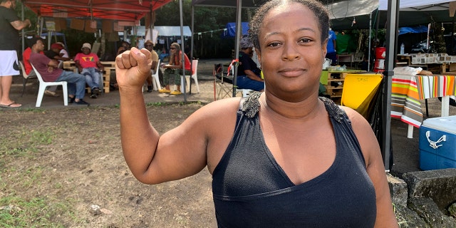 Marylis Colzin, uma enfermeira que protesta contra a vacinação da equipe médica exigida na França, posa em Pointe-a-Pitre, na ilha de Guadalupe, no domingo, 21 de novembro de 2021. 