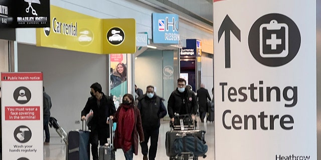 Passengers arrive at Heathrow Airport in London, Maandag, Nov.. 29, 2021. The new potentially more contagious omicron variant of the coronavirus popped up in more European countries on Saturday, just days after being identified in South Africa, leaving governments around the world scrambling to stop the spread. In Britain, Prime Minister Boris Johnson said mask-wearing in shops and on public transport will be required, starting Tuesday.