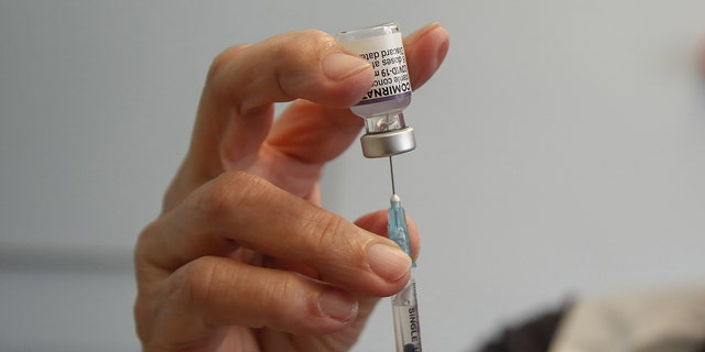 A health worker in the U.K. prepares to administer a dose of Pfizer/BioNTech COVID-19 vaccine at a vaccination center. Soon, children in the United States may be able to receive the COVID-19 vaccine.