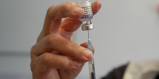 Um profissional de saúde no Reino Unido se prepara para administrar uma dose da vacina Pfizer / BioNTech COVID-19 em um centro de vacinação. Em breve, crianças nos Estados Unidos poderão receber a vacina COVID-19.