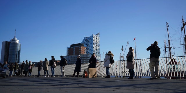 People queue up in a line several hundred meters long for the vaccination campaign at the Elbphilharmonie in Hamburg, Germany, Monday, Nov. 22, 2021. 