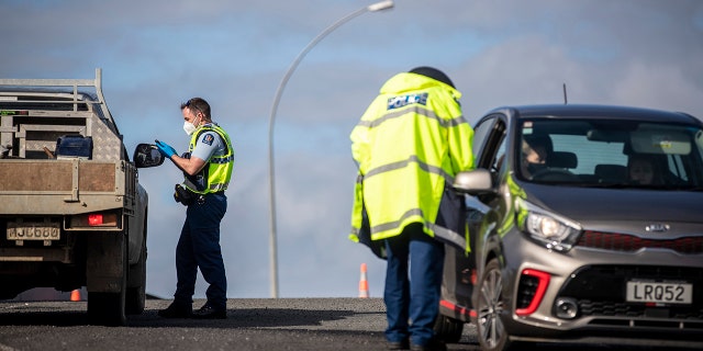 Police inspect vehicles at a road block on the outskirts of Auckland, New Zealand on Sept. 30, 2021. 