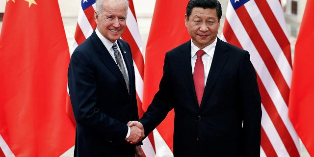 FILE PHOTO: Chinese President Xi Jinping shakes hands with U.S. Vice President Joe Biden (L) inside the Great Hall of the People in Beijing December 4, 2013.