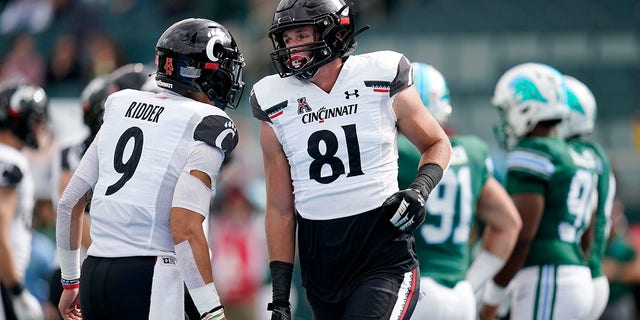 Cincinnati tight end Josh Whyle (81) celebrates his touchdown reception with quarterback Desmond Ridder (9) during the first half of an NCAA college football game against Tulane in New Orleans, Saturday, Oct. 30, 2021. Cincinnati won 31-12. 