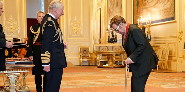 Sir Elton John is made a member of the Order of the Companions of Honour by Prince Charles during an investiture ceremony at Windsor Castle, in Windsor, England, on Wednesday, Nov. 10, 2021.