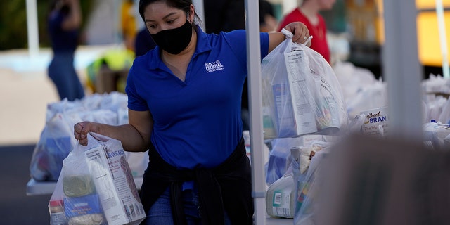 A volunteer loads food into a car at an Armed Services YMCA food distribution event in Oct. 2021 in San Diego, California. 
