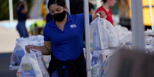 A volunteer loads food into a car at an Armed Services YMCA food distribution event in Oct. 2021 in San Diego, California.
