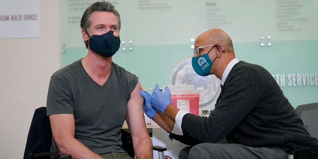 California Gov. Gavin Newsom, left, receives a Moderna COVID-19 vaccine booster shot from California Health and Human Services Secretary Dr. Mark Ghaly at Asian Health Services in Oakland, Calif., Wednesday, Oct. 27, 2021. (AP Photo/Jeff Chiu)
