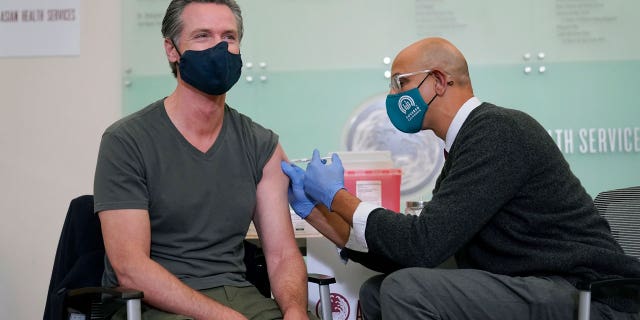 California Gov. Gavin Newsom, left, receives a Moderna COVID-19 vaccine booster shot from California Health and Human Services Secretary Dr. Mark Ghaly at Asian Health Services in Oakland, Calif., Wednesday, Oct. 27, 2021. (AP Photo/Jeff Chiu)