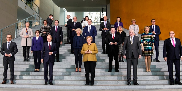 La chancelière allemande Angela Merkel, au centre, pose avec son gouvernement après la réunion du Cabinet à la chancellerie de Berlin le mercredi 24 novembre 2021.
