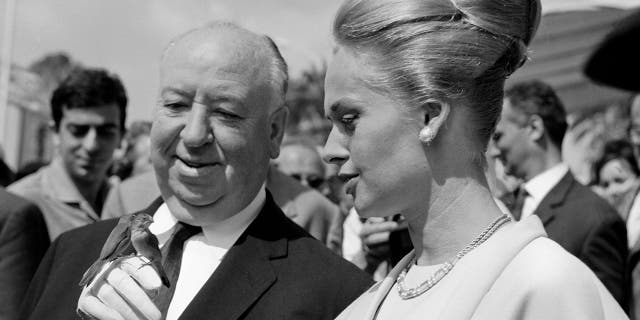 Alfred Hitchcock and Tippi Hedren with a bird on the hand in the Cannes film festival, on the occasion of the presentation of the movie "Birds."