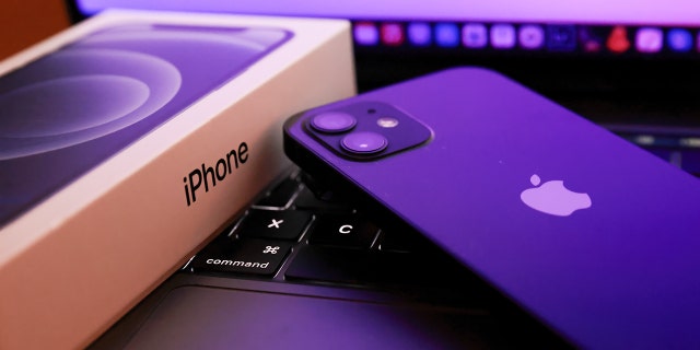 In this photo illustration, Apples iPhone 12 seen placed on a MacBook Pro. Kim Komando recently revealed her tips to organize photos and documents.