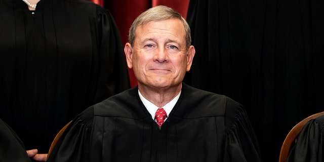 Chief Justice John Roberts sits during a group photo of the justices at the Supreme Court in Washington, D.C., on April 23, 2021. The justice has battled seizures.