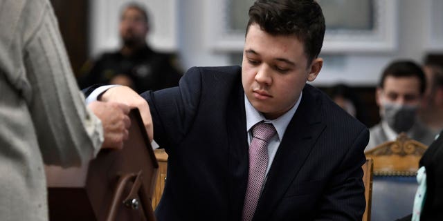 Kyle Rittenhouse pulls numbers of jurors out of a tumbler during his trail at the Kenosha County Courthouse in Kenosha, Wis., on Tuesday, Nov. 16, 2021. The jurors selected through this process will not participate in deliberations.