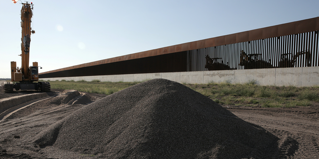 Workers continue the assembly of a border wall at a construction site in Pharr, Texas, Oct. 5, 2021. 