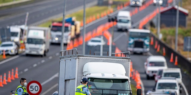 Police inspect vehicles at a road block on the outskirts of Auckland, New Zealand on Oct. 27, 2021. 