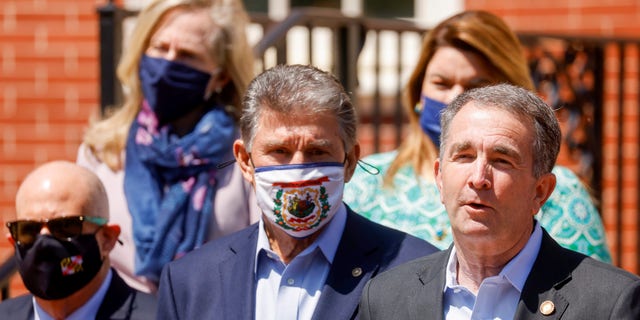 Sen. Joe Manchin III, D-WV, center, Maryland Gov. Larry Hogan, left, and Rep. Abigail Spanberger, D-Va., rear left, listen as Virginia Governor Ralph Northam addresses a news conference at the end of an 'infrastructure summit' in Annapolis. April 23, 2021. REUTERS/Jonathan Ernst