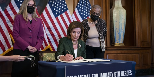 Speaker of the House Nancy Pelosi, D-Calif., signs H.R. 3325 during a bill enrollment ceremony with Rep. Jennifer Wexton, D-Va., left, and Rep. Eleanor Holmes Norton, D-D.C., at the U.S. Capitol on Wednesday, Aug. 4, 2021.