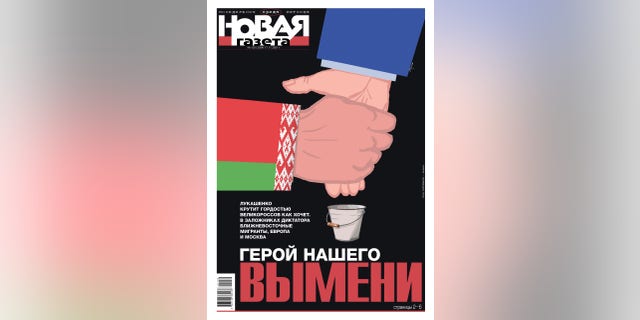 This photo shows a political cartoon featured on a magazine depicting Lukashenko and Putin, with one hand milking the other hand.