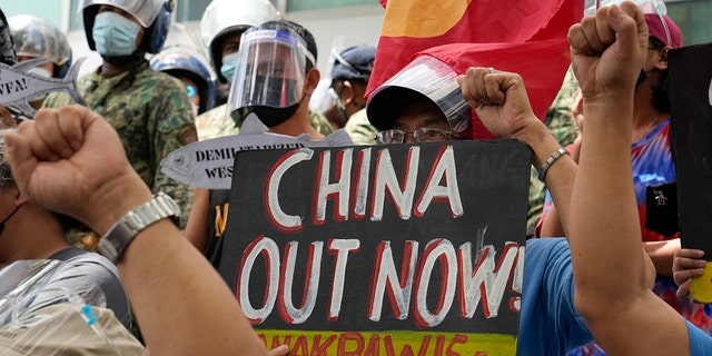 Des manifestants brandissent des slogans lors d'un rassemblement devant le consulat chinois dans la ville de Makati, aux Philippines, le 12 juillet 2021. 