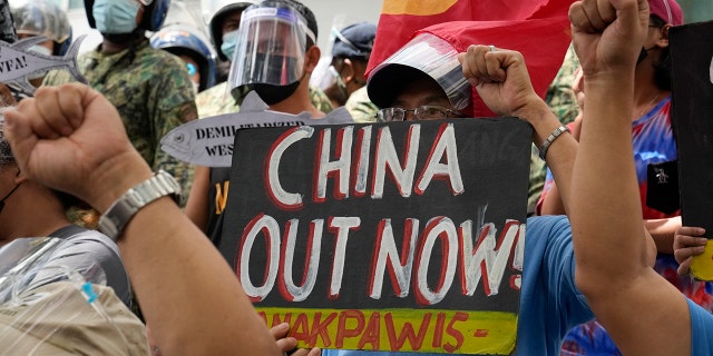 Protesters hold slogans during a rally in front of the Chinese Consulate in Makati city, Philippines, on July 12, 2021.