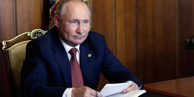 Russia's President Vladimir Putin attends a meeting of the Supreme State Council of the Union State of Russia and Belarus on Unity Day, via teleconference call, in Sevastopol, Crimea, on Nov. 4, 2021. One journalist is suggesting that Putin was effectively blackmailed by the president of Belarus over the migrant crisis.
