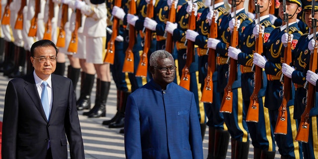 Chinese Premier Li Keqiang, left, and Solomon Islands Prime Minister Manasseh Sogavare review an honor guard during a welcome ceremony at the Great Hall of the People in Beijing on Wednesday, Oct. 9, 2019. 