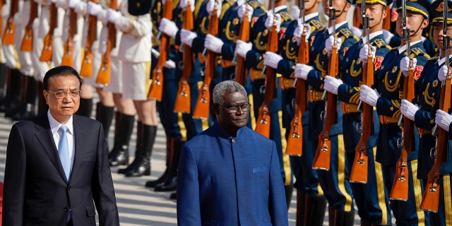 Chinese Premier Li Keqiang, left, and Solomon Islands Prime Minister Manasseh Sogavare review an honor guard during a welcome ceremony at the Great Hall of the People in Beijing on Wednesday, Oct. 9, 2019.