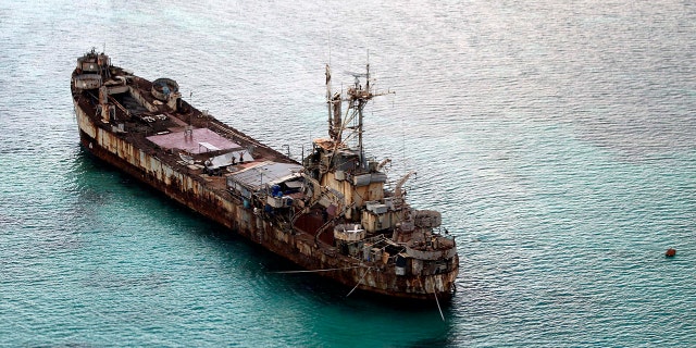 Cette photo aérienne prise à travers la vitre d'un avion militaire montre le navire délabré Sierra Madre de la marine philippine ancré près d'Ayungin Shoal avec des soldats philippins à bord pour sécuriser le périmètre dans les îles Spratly en mer de Chine méridionale le 11 mai 2015. 