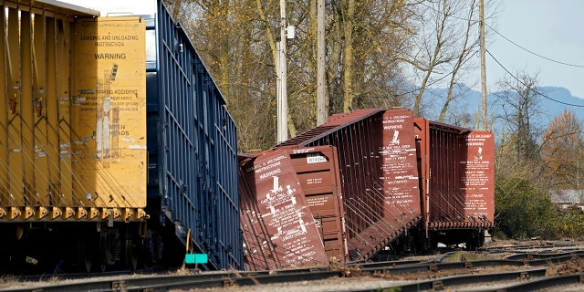 Railroad cars derailed by flooding sit near tracks at a BNSF rail yard Wednesday, Nov. 17, 2021, in Sumas, Washington.