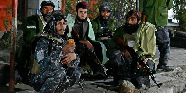 Taliban fighters sit along the roadside near Sardar Mohammad Dawood Khan military hospital in Kabul on Nov. 2 after people were killed and wounded in an attack on a military hospital. 