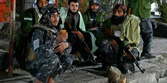 Taliban fighters sit along the roadside near Sardar Mohammad Dawood Khan military hospital in Kabul on Nov. 2 after people were killed and wounded in an attack on a military hospital.